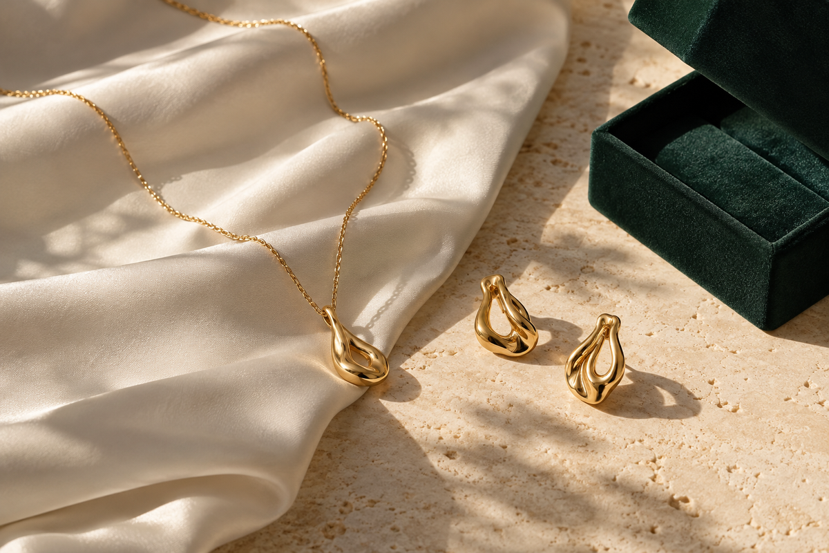 Illustrative jewellery gift edit on ivory silk with a forest green box
